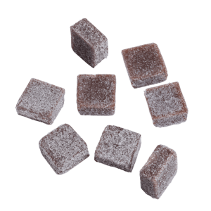 Nahaufnahme der PURE BOTANICA Euphoria Gummies mit weicher Fruchtgummi-Textur und feiner Zuckerschicht. Die Premium-Cannabis-Edibles sind als quadratische Fruchtgummis auf hellem Hintergrund arrangiert und unterstreichen die hochwertige Qualität und das moderne Design der Marke.