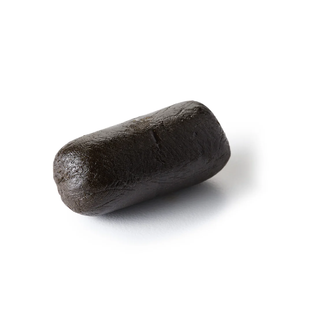 Belipa CBD Hasch – Premium Vollspektrum-Haschisch Nahaufnahme | Pure Botanica Nahaufnahme eines halbierten Stücks dunkelbraunen CBD-Haschischs mit weicher, dichter Innenstruktur auf weißem Hintergrund – Premium Vollspektrum-CBD-Hasch von Pure Botanica.