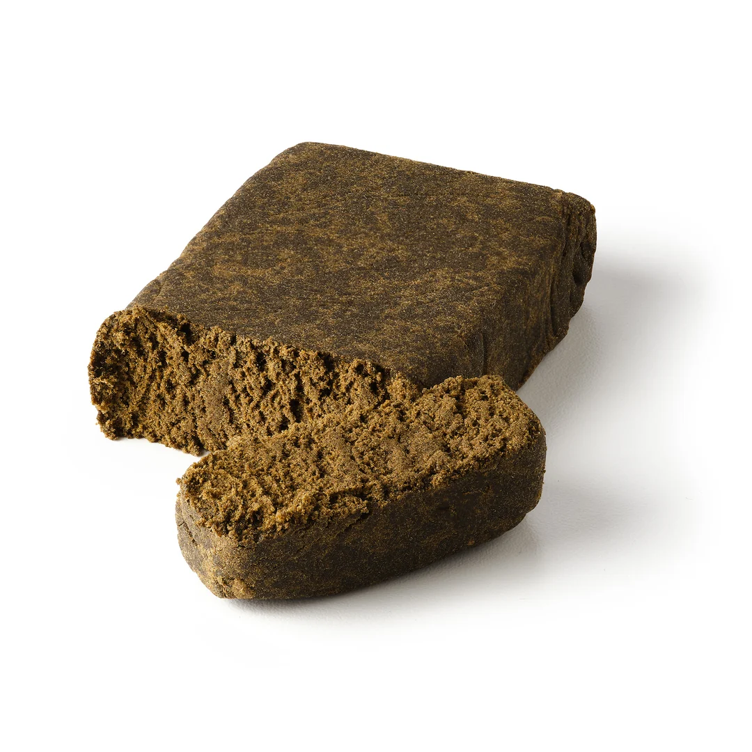 KingHassan | CBD + CBG Hash Close-up of a premium CBD hash block with a freshly cut piece revealing its soft, crumbly texture. High-quality hemp hash crafted from CBD-rich cannabis, ideal for customers seeking authentic traditional hash with natural aroma and premium quality.