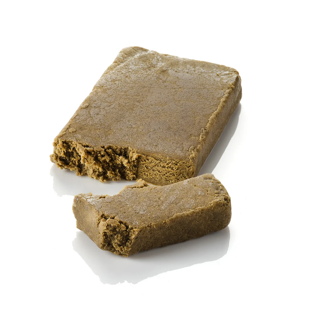 Super Pollen | CBD Hash Deutschland | Außergewöhnlicher Standard | 21 % CBD Makroaufnahme eines PURE BOTANICA CBD Hash Super Pollen Blocks mit dichter, weicher und harzreicher Struktur. Die Nahaufnahme zeigt die hochwertige Textur und Premium-Qualität von Vollspektrum-CBD-Hasch vor einem sauberen weißen Hintergrund – ideal für hochwertige CBD- und Hanfprodukte.
