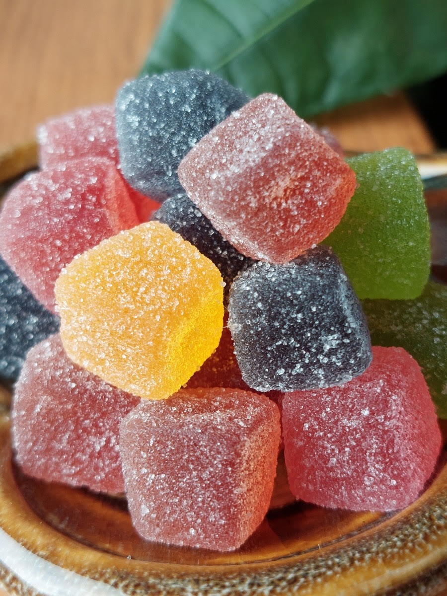 CBD-Gummibärchen – 750 mg Whole Circle Farms CBD vegane Gummibonbons in einer Flasche neben einer Auswahl bunter CBD-Gummibonbons auf einem Holztisch.